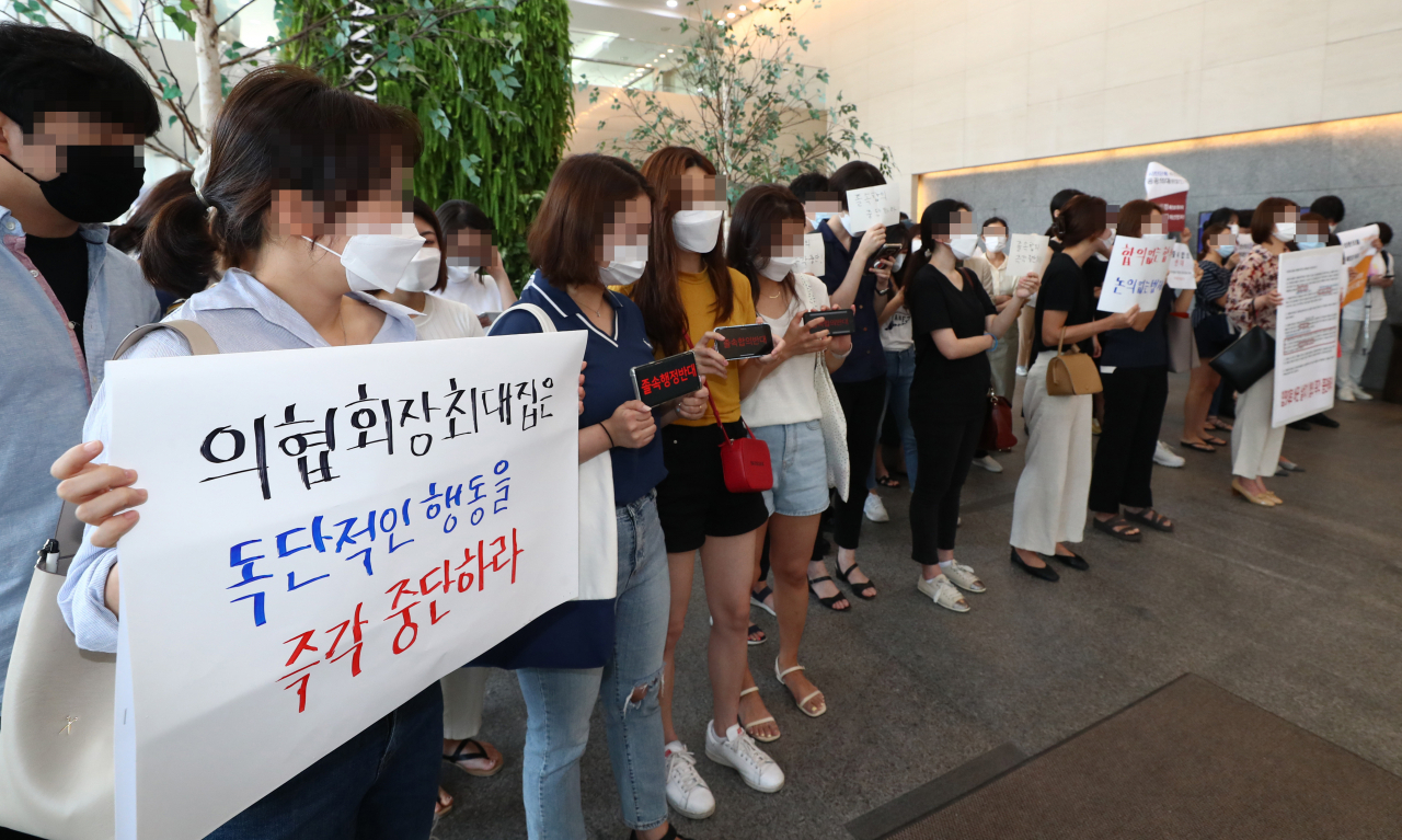 전공의들이 4일 오후 서울 중구 한국증진개발원에서 열리는 '의대정원 원점 재논의 정책협약 이행합의서 체결 협약식'을 막기 위해 로비에 모여 있다. [사진=연합뉴스]