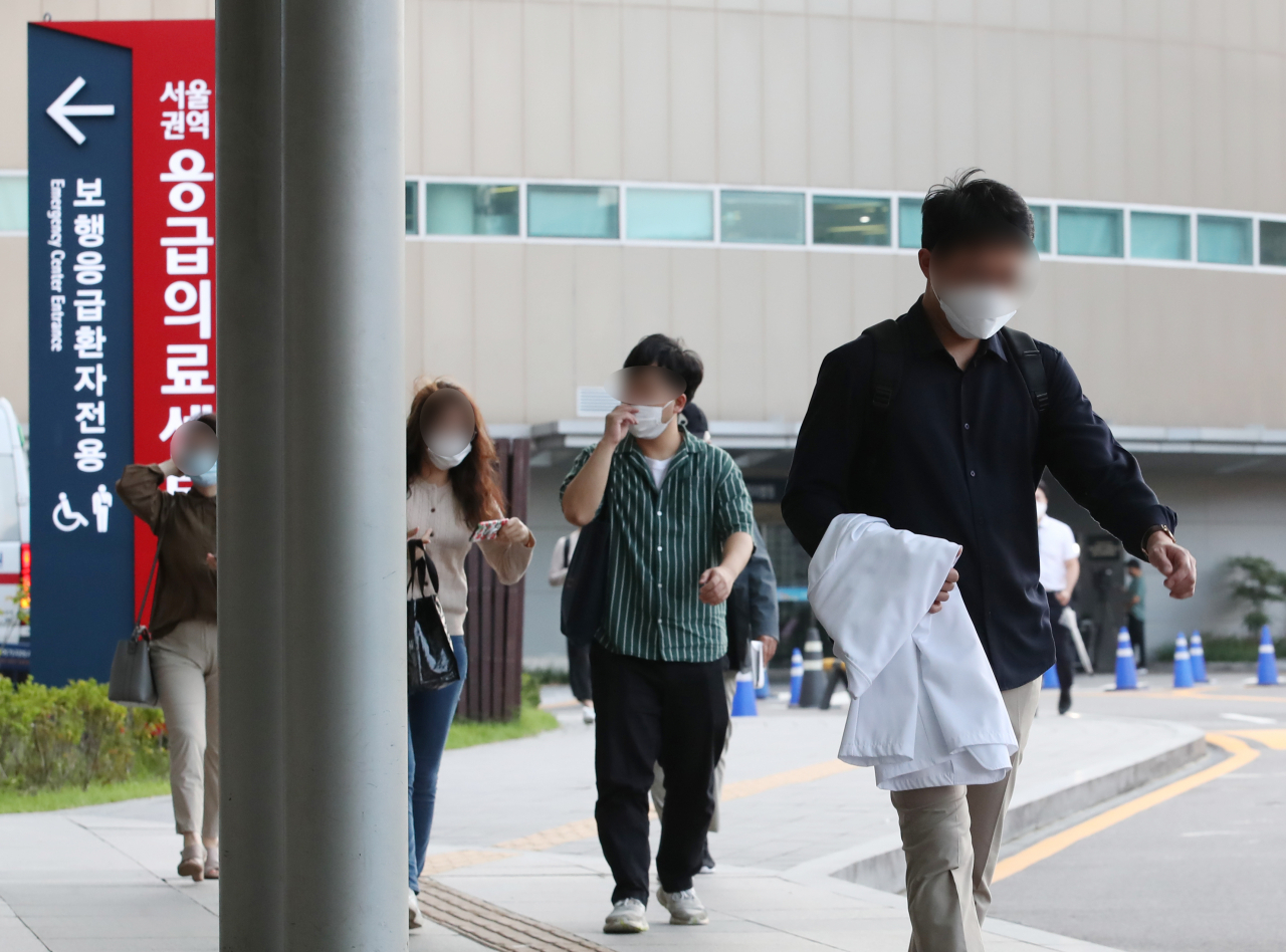 전공의들이 집단휴진을 벌인 지 18일 만에 업무에 복귀한 8일 오전 서울 종로구 서울대학교병원에서 전공의가 가운을 들고 이동하고 있다. [연합]