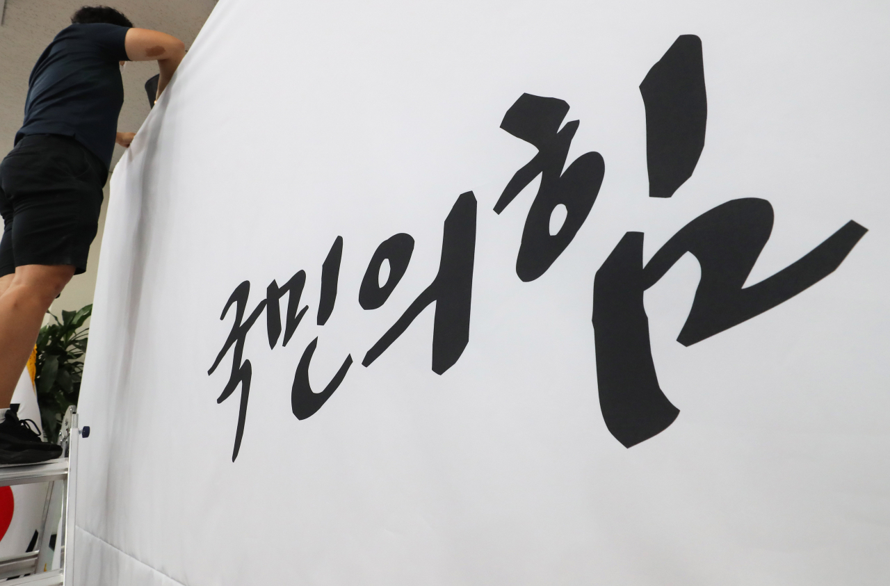 3일 오전 국민의힘 관계자가 국회 당 대회의실 백드롭을 교체하고 있다. 미래통합당은 지난 2일 '국민의 힘'으로 당명을 교체했다.[연합]