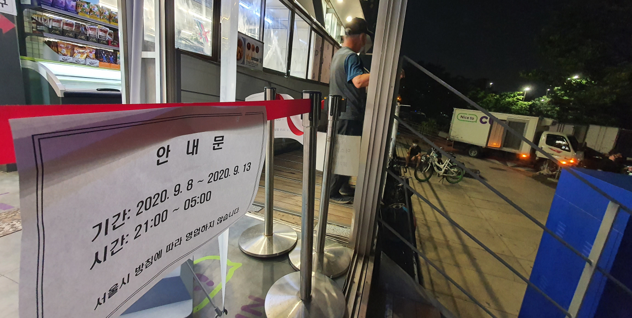 8일 밤 9시 영업을 마친 여의도 한강공원 매점에 영업시간 안내문이 붙어 있다. [연합]