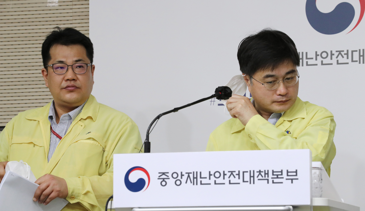 윤태호 중앙사고수습본부 방역총괄반장(오른쪽)이 9일 오전 세종시 정부세종청사에서 열린 신종 코로나바이러스 감염증(코로나19) 대응 정례브리핑을 마친 뒤 이어진 취재진의 질문에 답변하기 위해 마스크를 벗고 있다. 왼쪽은 손영래 중앙사고수습본부 전략기획반장. [연합]
