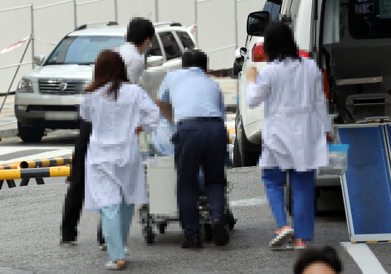 ‘의료정상화까지 남은 과제는&hellip;.’ 전공의들이 무기한 집단휴진을 끝내고 병원으로 돌아온 가운데 서울대 의과대학 본과 4학년 학생 81%는 내부 설문조사를 통해 동맹휴학 및 의사 국가고시를 계속 거부하는 데 반대한다고 밝혔다. 9일 오전 서울 종로구 서울대병원 어린이병동에서 의료진이 환자를 이송하고 있다. [연합]