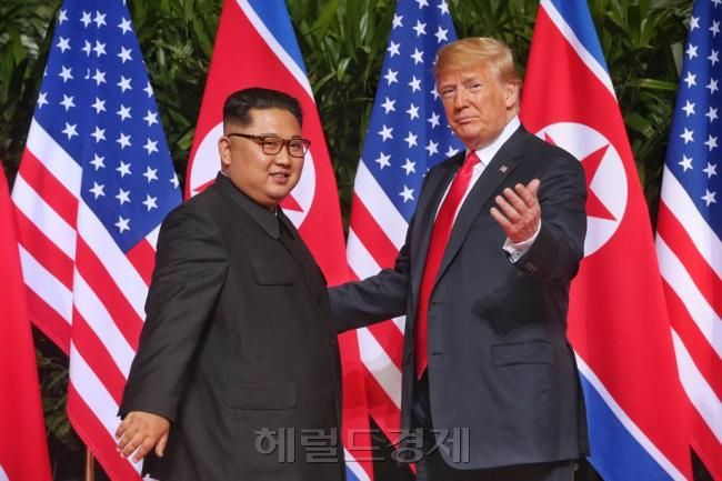 김정은 북한 국무위원장과 도널드 트럼프 미국 대통령이 지난 2018년 6월12일 싱가포르에서 처음 만나 악수를 나눈 뒤 기자들을 향해 자세를 취하고 있다. [헤럴드DB]