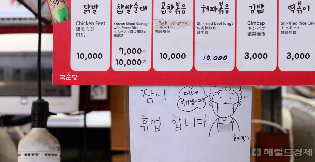 [헤럴드경제=이상섭 기자] 코로나19 재확산으로 소상공인의 고통이 가중되고 있는 가운데 9일 오전 서울 광장시장의 한 가게에 붙은 휴업 안내문에 "다 함께 이겨냅시다"라는 문구가 적혀 있다. babtong@heraldcorp.com