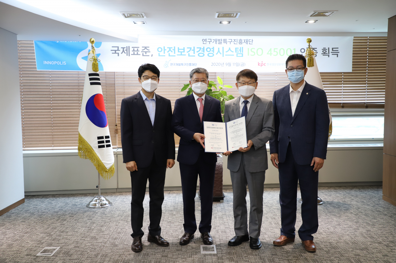 양성광(오른쪽 두번째) 연구개발특구진흥재단 이사장과 정의식(왼쪽 두번째) 한국생산성본부인증원 원장이 ISO 45001 국제표준 인증서를 전달하고 기념촬영을 하고 있다.[연구개발특구진흥재단 제공]