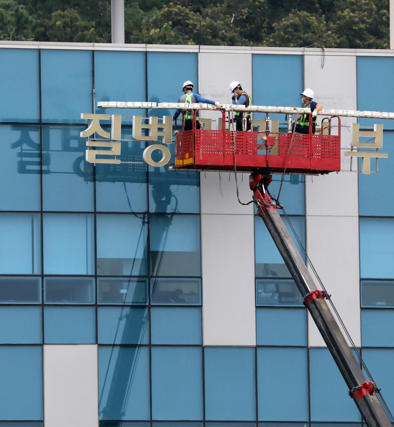 지난 11일 오후 충북 청주시 질병관리본부 본청 간판이 '질병관리청'으로 새롭게 교체하기 위해 내려지고 있다. [연합]