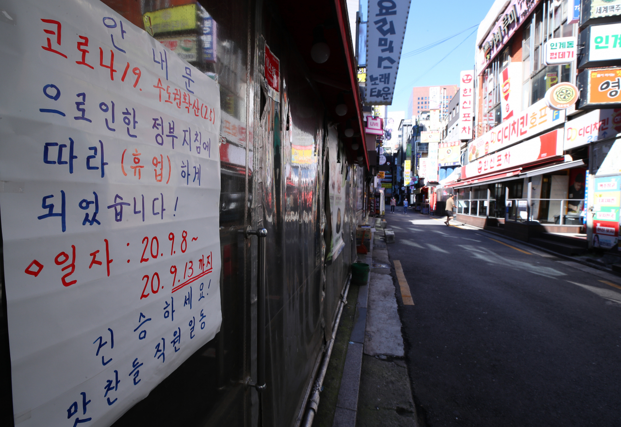 정부가 수도권의 사회적 거리두기 조치를 2주 동안 2단계로 조정하기로 결정한 지난 13일 오전 서울 종로의 한 식당 입구에 휴업 안내문이 붙어 있다. [연합]