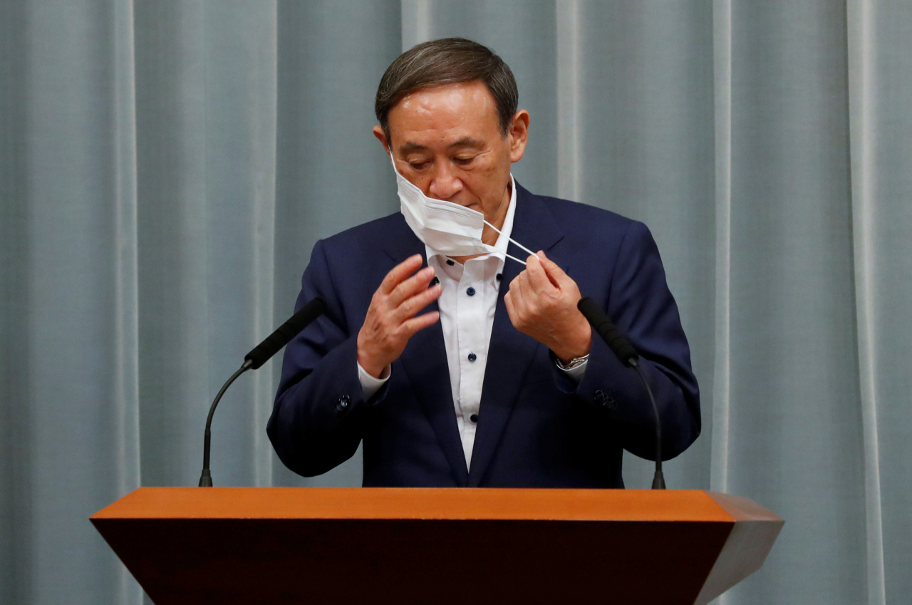 아베 신조 일본 총리의 후임으로 유력한 스가 요시히데 관방장관이 14일 도쿄 총리관저에서 열린 정례 기자회견을 위해 신종 코로나바이러스 감염증(코로나19) 예방 마스크를 벗고 있다. [연합]