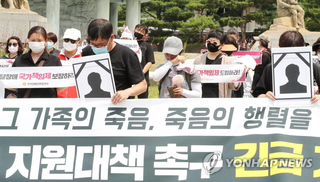 지난 6월 10일 청와대 분수대 앞에서 열린 발달장애인 가족 보건복지부 규탄 및 지원대책 촉구 긴급 기자회견에서 한 참석자가 6월 3일 광주에서 사망한 발달장애인과 가족의 추모사를 시작하자 많은 참석자들이 눈물을 흘리고 있다. [연합]