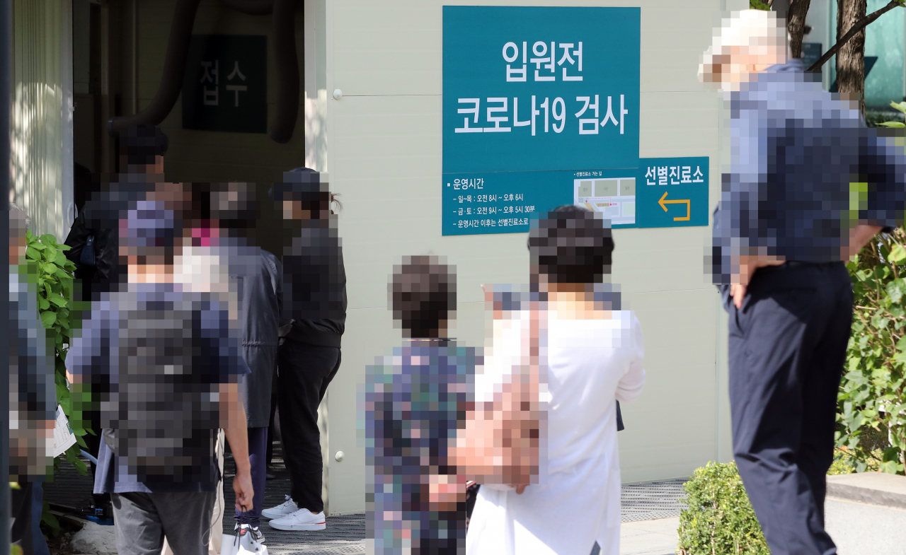 입원 환자에 이어 보호자에게도 신종 코로나바이러스 감염증 검사를 의무화하기로 한 서울 아산병원에서 14일 입원 예정자들이 코로나19 검사를 위해 대기하고 있다. 서울아산병원은 원칙적으로 입원 환자당 보호자는 1명으로 제한하고 검사를 시행하되 불가피하게 보호자가 교대해야 할 경우 1명 더 허용하기로 했다. 연합뉴스