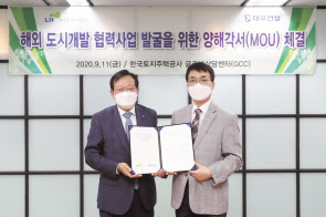 김창환(왼쪽) 대우건설 신사업본부장과 이용삼 한국토지주택공사(LH) 글로벌사업본부장이 양해각서를 체결한 모습. [대우건설 제공]