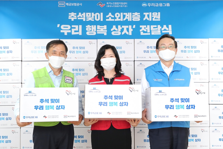 우리금융과 예금보험공사는 우리 농산품으로 채운 우리행복상자 2000개를 지난 15일 독거노인종합지원센터에 전달했다. 손태승 우리금융 회장(오른쪽), 김현미 독거노인종합지원센터장(가운데), 위성백 예금보험공사 사장(왼쪽)이 기념촬영을 하고 있다. [우리금융 제공]