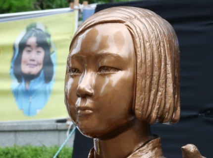 ‘일본군 위안부 피해자 기림의 날’인 지난 8월 14일 서울 종로구 옛 일본대사관 앞 소녀상 뒤로 정의기억연대 전 이사장 윤미향 의원의 사진이 담긴 현수막이 보이고 있다. [연합]