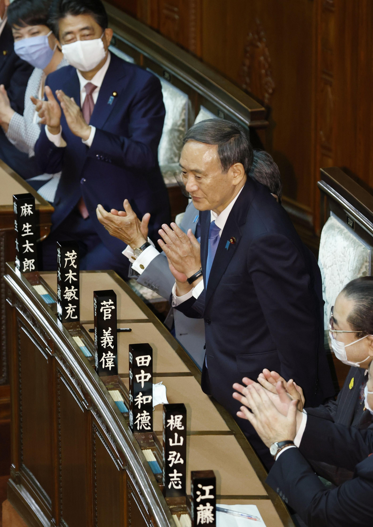 일본 중의원은 16일 본회의를 열고 제99대 총리로 스가 요시히데(菅義偉) 자민당 총재를 선출했다. 사진은 이날 오후 총리로 지명된 순간 일어나서 인사하는 스가 총재와 아베 신조(安倍晋三) 전 총리. [연합]