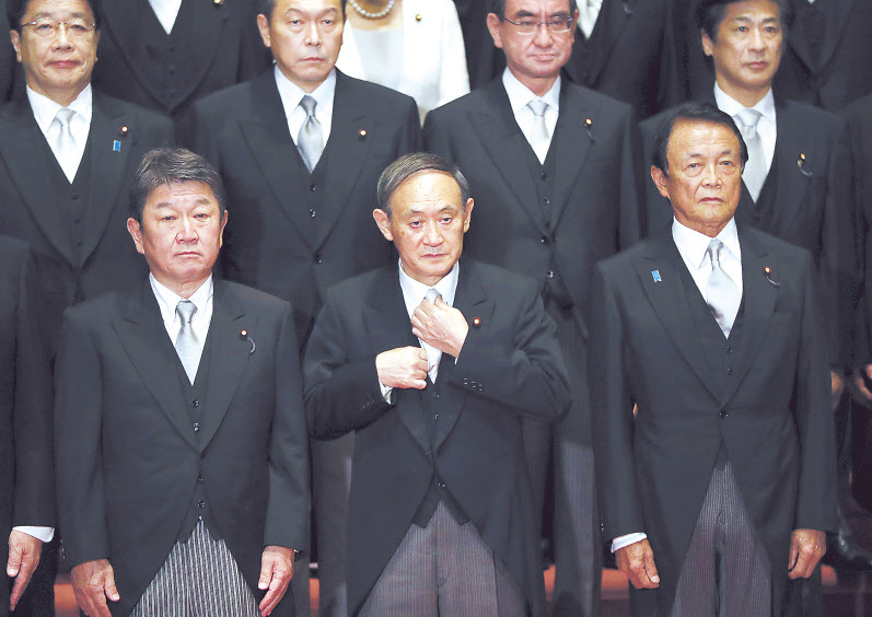 스가 요시히데(가운데) 일본 신임 총리와 새 내각의 각료들이 지난 16일 총리 관저에서 기념사진을 찍고 있다. 스가 총리 오른쪽은 연임에 성공한 아소 다로 부총리 겸 재무상, 왼쪽은 모테기 도시미쓰 외무상. [AP 연합]
