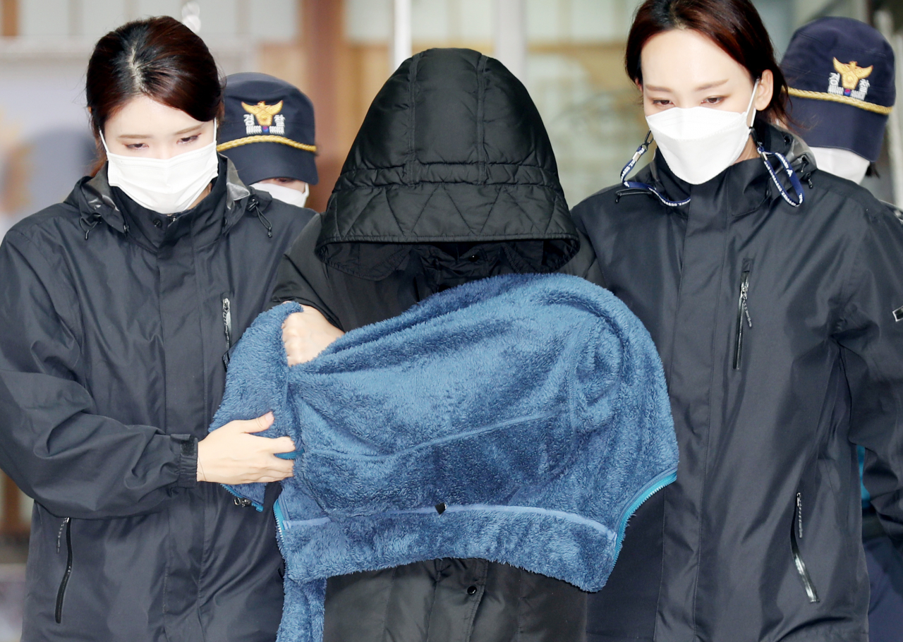 인천 을왕리해수욕장 인근에서 치킨 배달을 하던 50대 가장을 치어 숨지게 한 음주 운전자 A씨(가운데)가 지난 14일 구속 전 피의자 심문(영장실질심사)을 받기 위해 인천시 중구 중부경찰서를 나오고 있다. [연합]