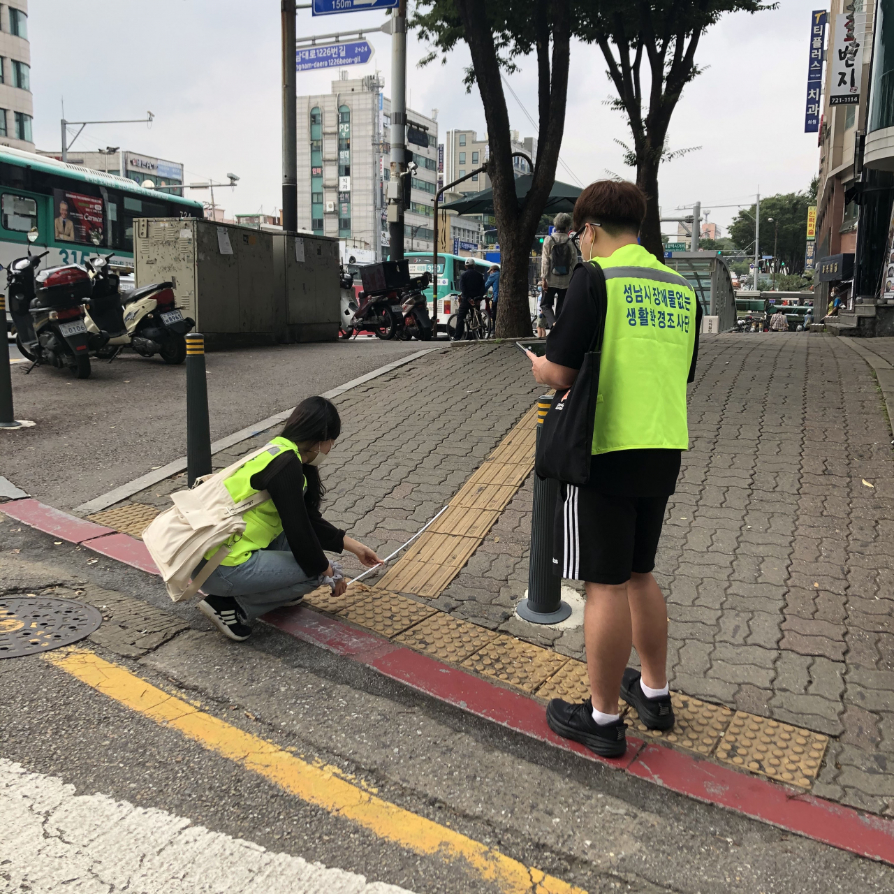 성남시 장애물 없는 생활환경 조사단이 수진동에서 휠체어 진입 도로의 길이를 재고 있다. [성남시 제공]