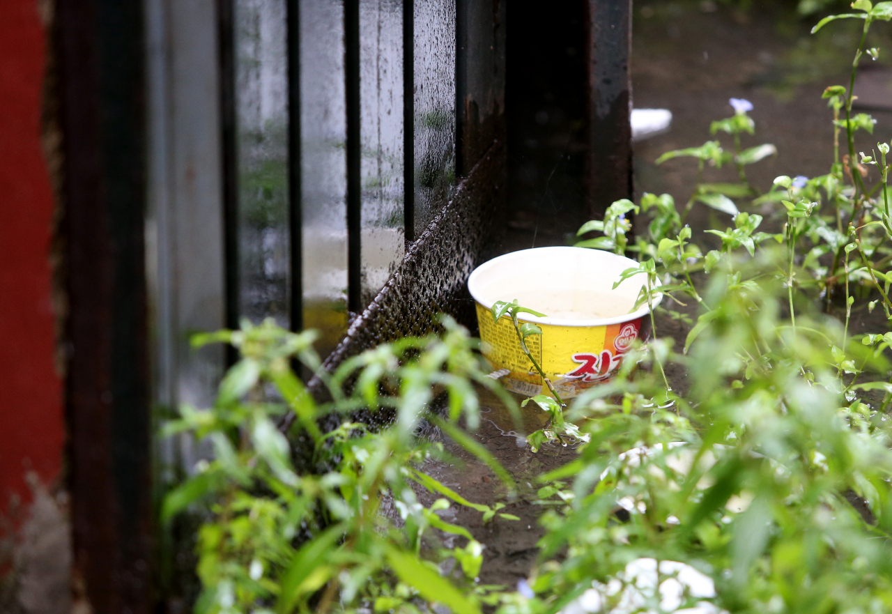 지난달 17일 초등학생 형제가 중화상을 입은 인천시 미추홀구 한 빌라에서 물청소 작업 중 떠밀려온 것으로 추정되는 컵라면 용기가 물웅덩이에 잠겨 있다. [연합]