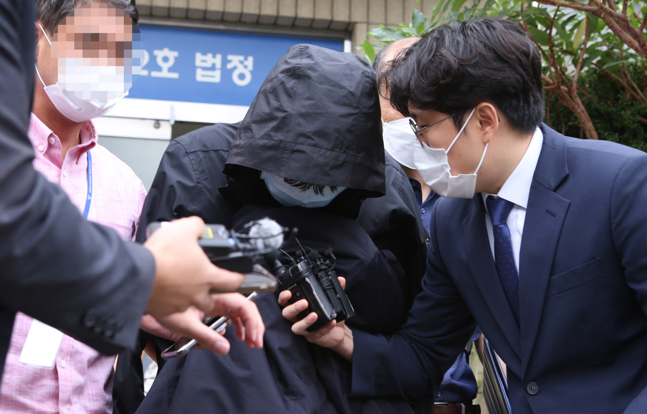 부산 해운대에서 '마약 질주'를 벌인 운전자가 18일 오전 부산지법 동부지원에서 구속 전 피의자 심문(영장실질심사)을 받고 난뒤 모습을 드러내자 취재진이 질문을 하고 있다. [연합]