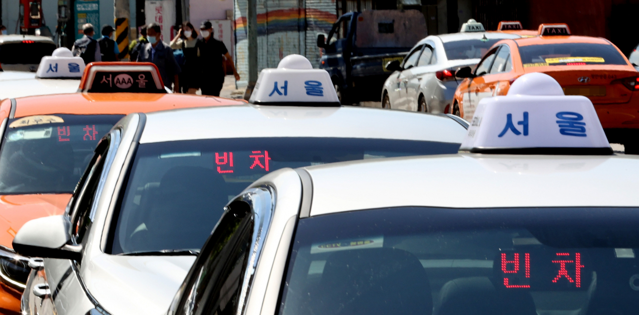 '코로나19' 재확산으로 인한 사회적 거리두기로 택시 운행 건수가 크게 감소한 가운데 18일 오전 서울역 앞에서 택시들이 줄지어 손님을 기다리고 있다. [연합]
