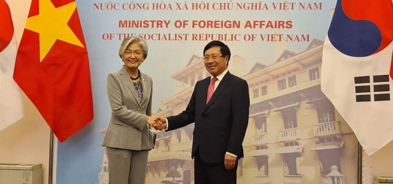 Foreign Minister Kang Kyung-wha (left) shakes hands with her Vietnamese counterpart, Pham Binh Minh, before their talks in Hanoi on Sept. 18, 2020. (Yonhap)