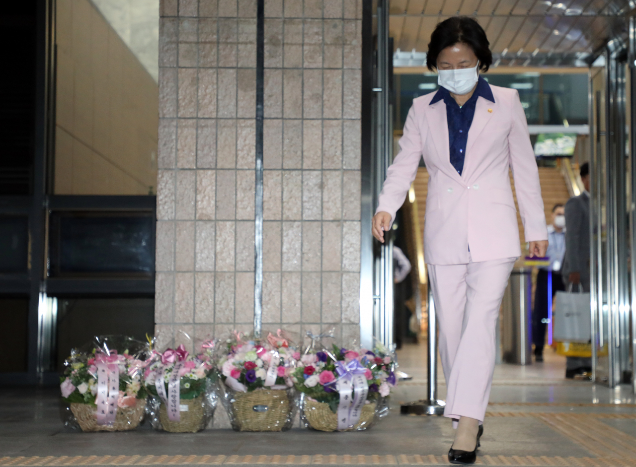 추미애 법무부 장관이 18일 저녁 정부과천청사에서 퇴근하고 있다. 뒤로 지지자들이 보낸 꽃바구니가 보인다. [연합]