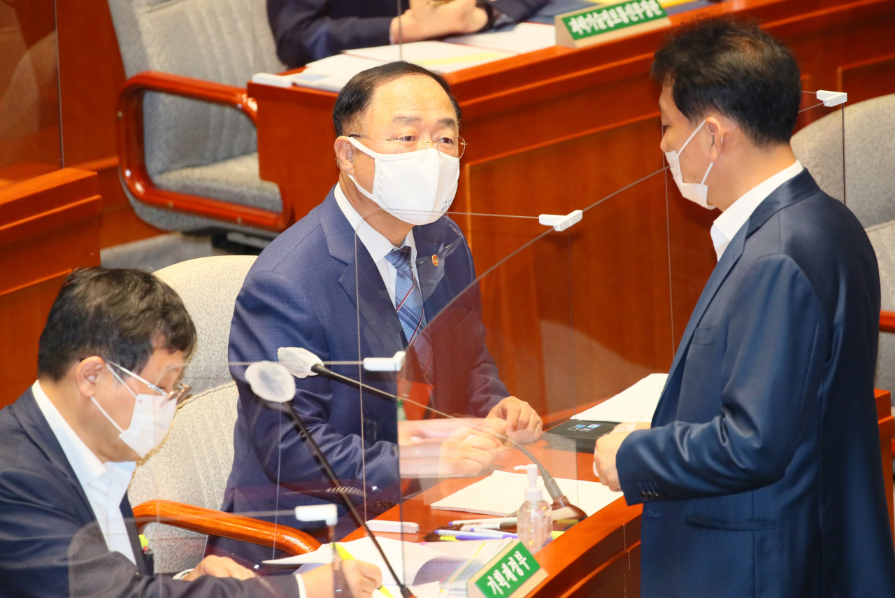 홍남기 경제부총리가 18일 국회 예산결산특별위원회 전체회의에서 더불어민주당 이광재 의원과 대화하고 있다. [연합]
