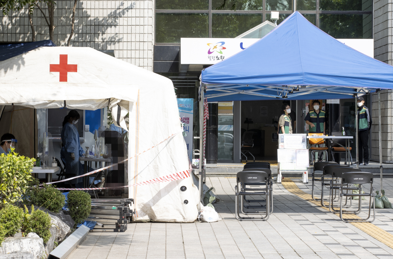 A visitor consults with a medical worker at a COVID-19 testing station at a community health center in Seoul earlier this week when the number of new cases stood at 109, including 11 entrants from abroad, marking the 12th consecutive day the figure had stayed in the 100 level. (Yonhap)