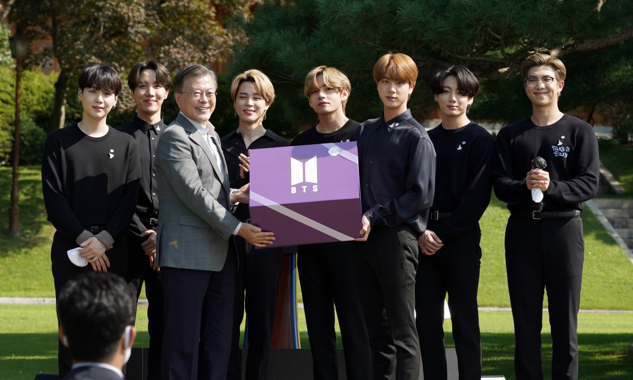 President Moon Jae-in receives a gift from BTS during the inaugural ceremony of the Youth Day on Saturday. (Yonhap)