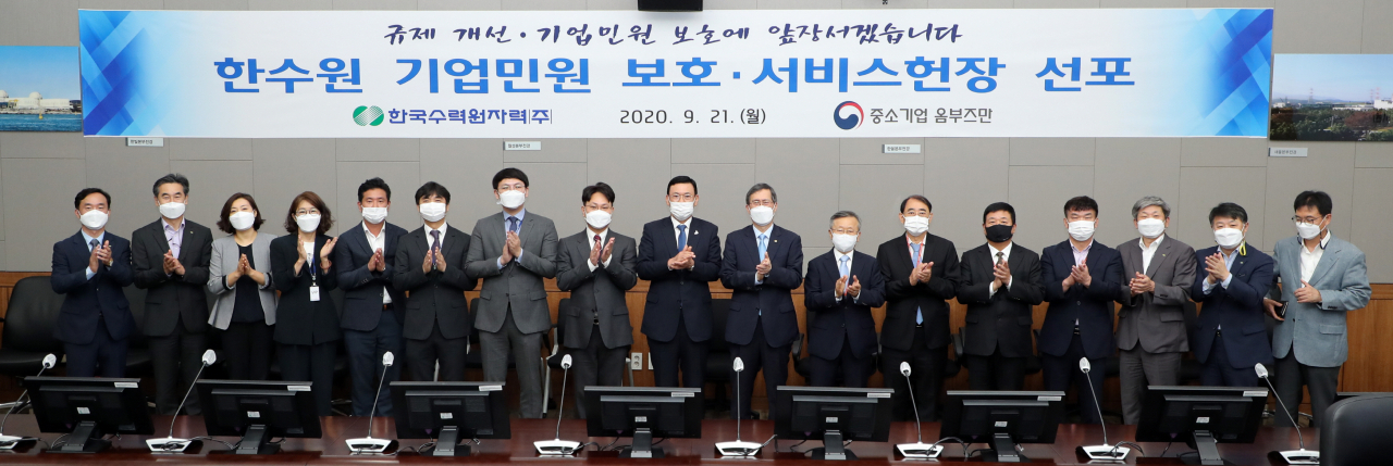 정재훈(오른쪽 8번째) 한국수력원자력 사장이 21일 경주 본사에서 열린 ‘기업민원 보호·서비스헌장 선포식’에서 기념촬영을 하고 있다.[한국수력원자력 제공］