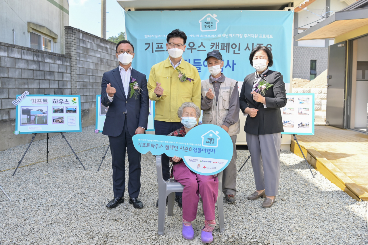 22일 충남 공주시 반포면에서 진행된 ‘기프트하우스 캠페인 시즌6’ 집들이행사에서 김정섭 공주시장(뒷줄 좌측에서 두 번째), 현대엔지니어링 엄홍석 커뮤니케이션실장(뒷줄 좌측 첫 번째), 김정희 희망브리지 전국재해구호협회 사무총장(뒷줄 오른쪽 첫 번째)이 기프트하우스 참여 주민과 기념사진을 촬영하고 있다. [현대엔지니어링 제공]