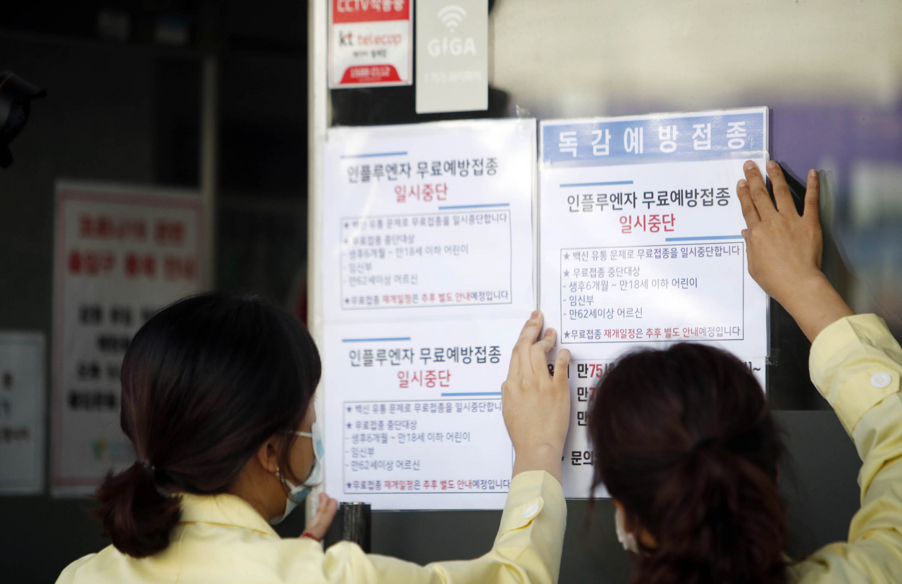 22일 오전 광주 북구의 한 병원에서 북구보건소 직원들이 인플루엔자(독감) 백신 무료접종 연기 안내문을 붙이고 있다. 연합뉴스
