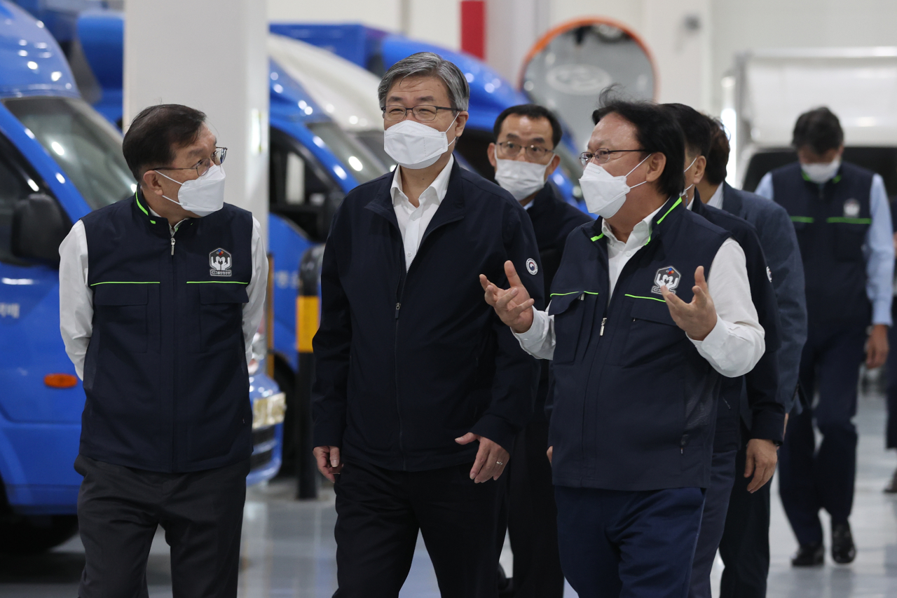 CJ Logistics CEO Park Keun-hee, right, briefs Labor Minister Lee Jae-kap, center, during the minister's visit to the parcel delivery firm's sorting center in Gimpo, Gyeonggi Province, on Wednesday. (Yonhap)