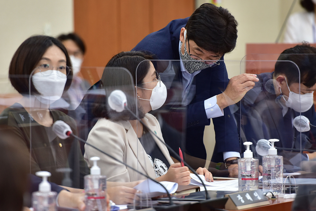 용혜인 기본소득당 의원(왼쪽)이 23일 국회 기획재정위원회 전체회의에서 고용진 더불어민주당 의원과 논의하고 있다. [연합]