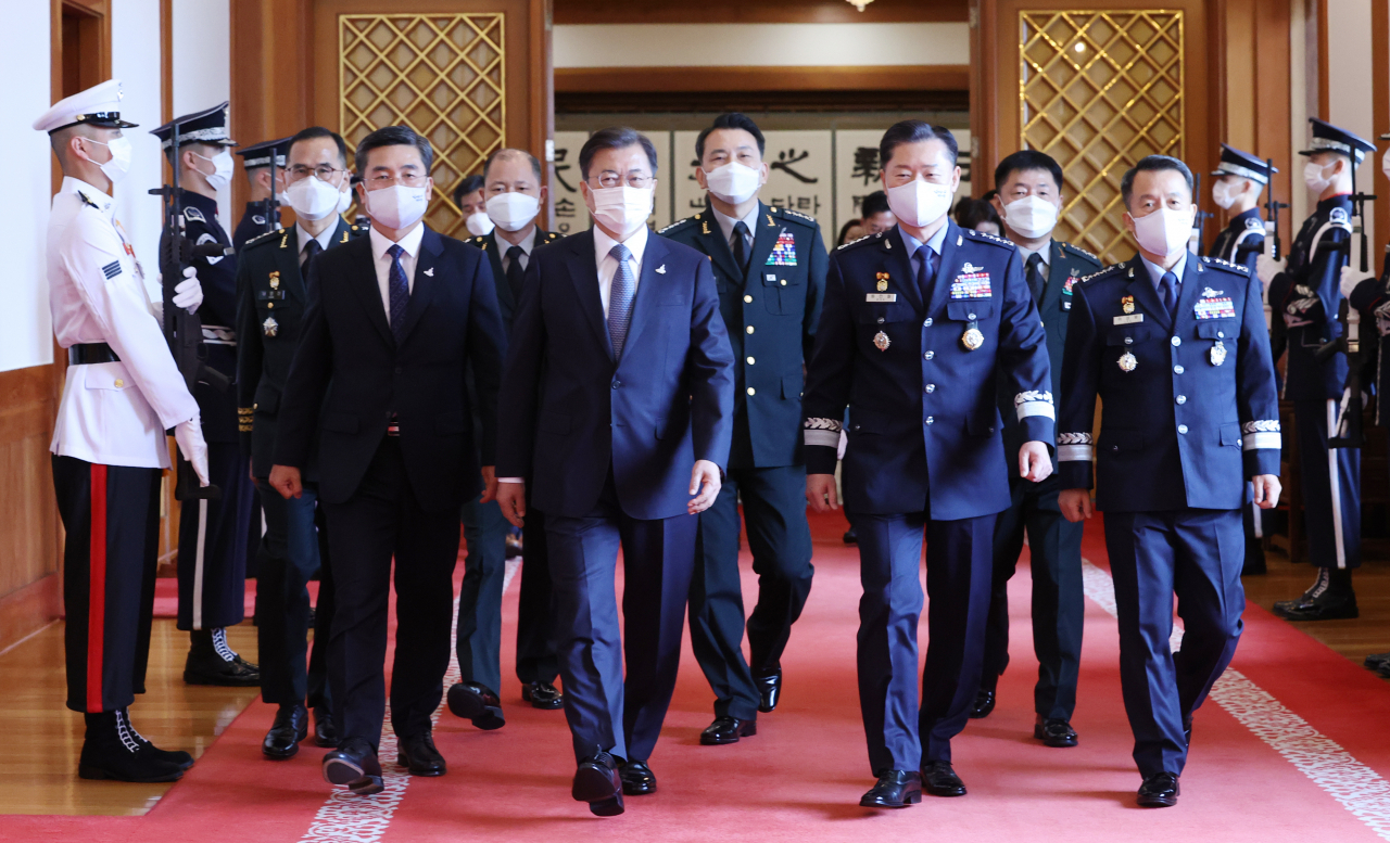 문재인 대통령이 23일 오전 청와대에서 군 장성 진급 및 보직 신고식을 마친 뒤 서욱 국방부 장관(왼쪽 두번째), 원인철 합참의장(왼쪽 여섯번째), 남영신 육군참모총장(왼쪽) 등 참석자들과 환담장으로 이동하고 있다.[연합]