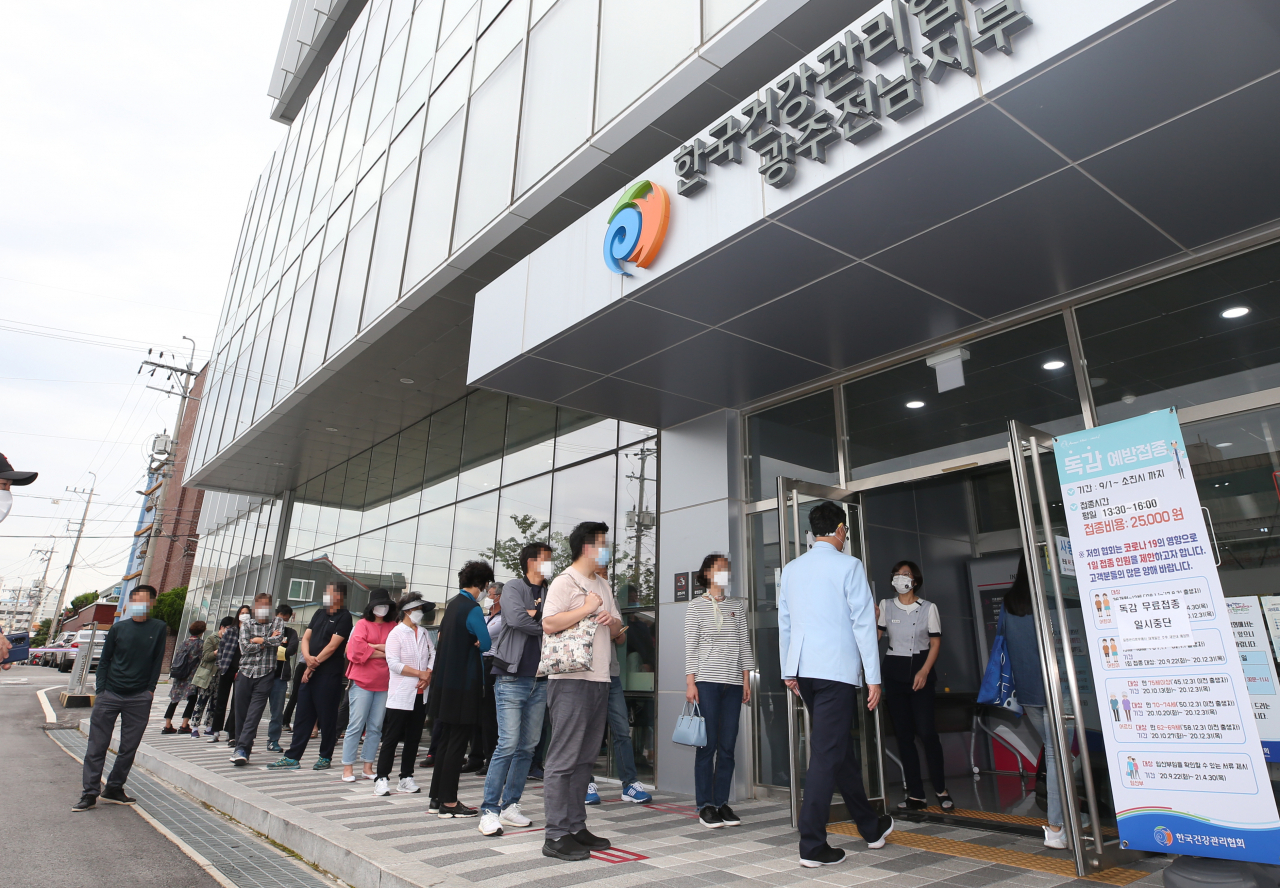 유통상의 문제가 발생해 무료 독감 예방접종 사업이 일시 중단된지 이틀째인 23일 오후 광주 서구 한국건강관리협회 광주전남지부에서 백신 수급 부족을 우려한 시민들이 유료로 독감 예방접종을 하기 위해 줄을 서 있다. 연합뉴스