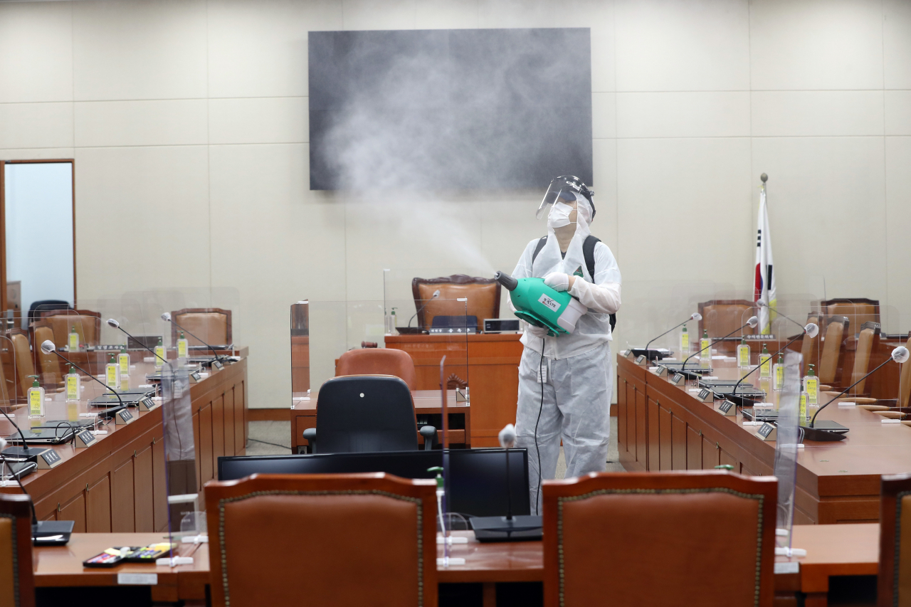 지난 7일 국회서 신종 코로나바이러스 감염증(코로나19) 확진자가 발생하면서 국회 본청 일부 공간과 소통관 등이 다시 폐쇄됐다. 7일 오후 국회의사당 본관 정무위원회 회의실에서 방역당국 관계자들이 방역작업을 하고 있다. [연합]