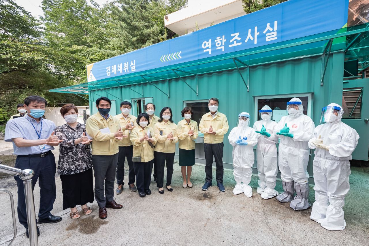 김선갑(오른쪽에서 다섯번째) 구청장과 구청 직원들, 보건소 의료진들이 선별진료소 앞에서 기념촬영을 하고 있다. [광진구 제공]