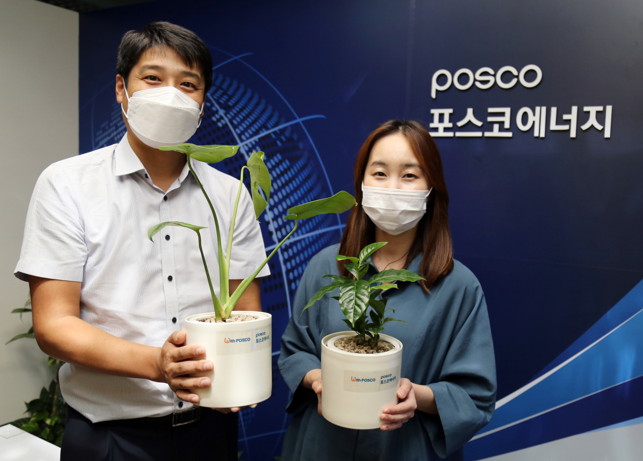 포스코에너지 직원들이 지역아동센터에 기증할 반려식물(걷기 목표 달성 선물)을 들고 기념촬영을 하고 있다. [포스코에너지 제공]
