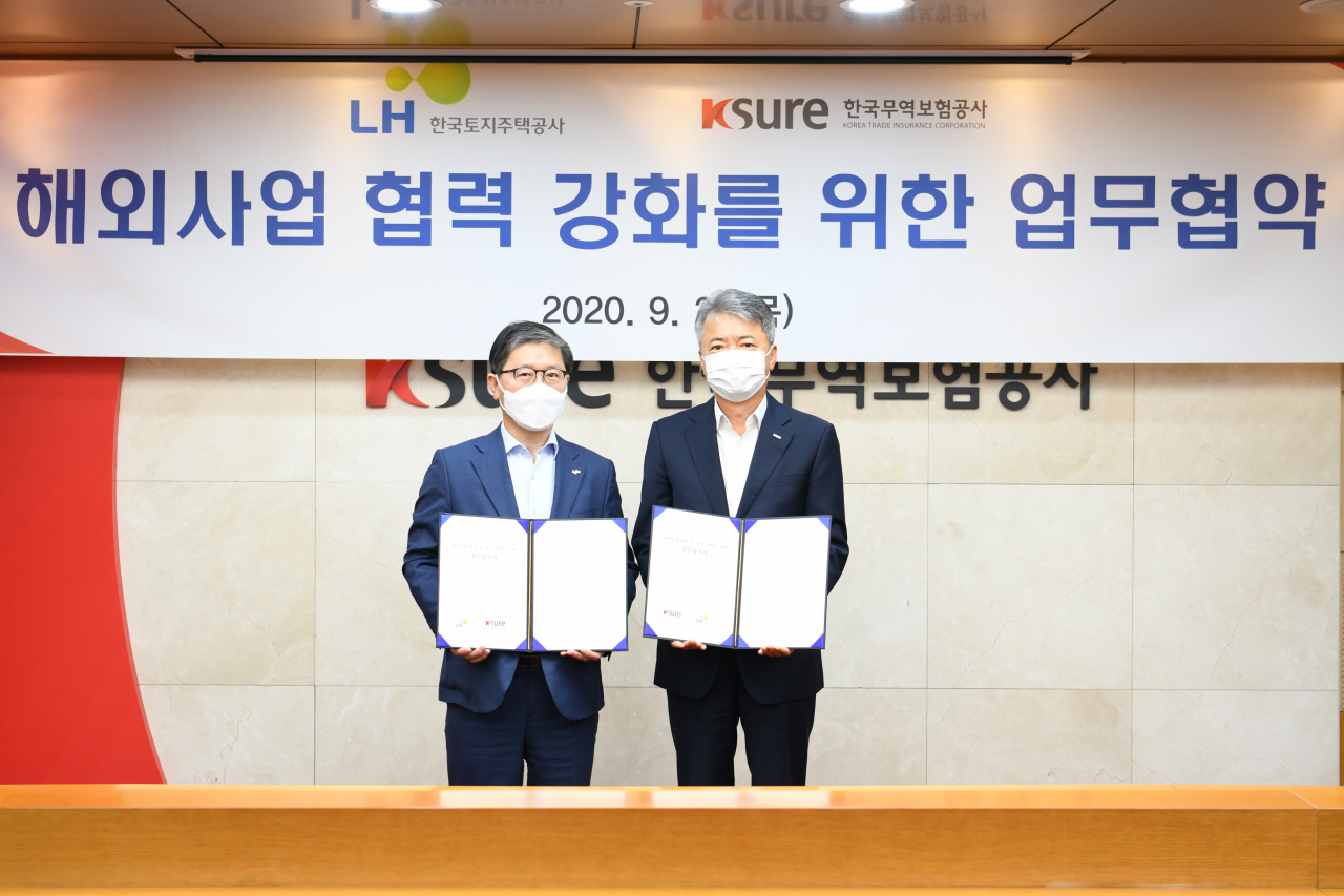 이인호(오른쪽) 한국무역보험공사 사장이 24일 서울 종로구 본사에서 진행된 국토지주택공사(LH)와의 '해외사업 협력 및 지원 강화를 위한 업무협약체결식'에서 기념촬영을 하고 있다.[한국무역보험공사 제공]