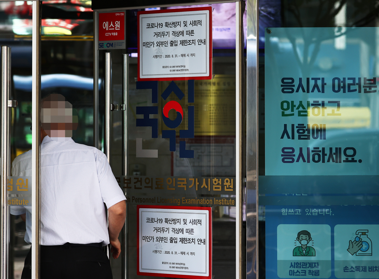 전국 의과대학 본과 4학년생들이 기존의 입장을 바꿔 국가고시 응시 의사를 표시한 24일 자양동에 위치한 한국보건의료인국가시험원(국시원)에 관계자가 출입구를 관리하고 있다. [연합]
