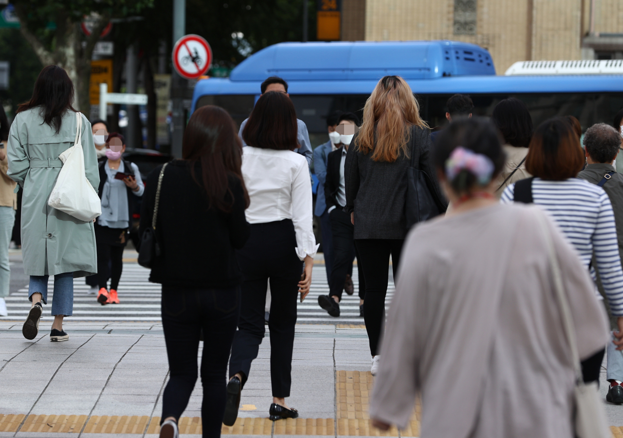 쌀쌀한 가을 아침인 지난 23일 오전 출근길 시민들이 평소보다 두꺼운 옷차림으로 서울 종로구 광화문 네거리를 지나고 있다. [연합]