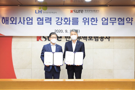 이인호(오른쪽) 한국무역보험공사 사장이 24일 서울 종로구 본사에서 진행된 국토지주택공사(LH)와의 ‘해외사업 협력 및 지원 강화를 위한 업무협약체결식’에서 기념촬영을 하고 있다. [한국무역보험공사 제공]