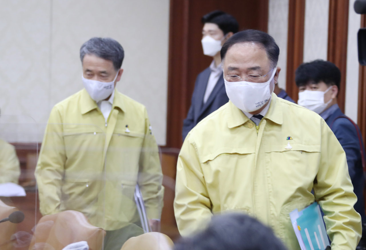 홍남기 부총리 겸 기획재정부 장관(오른쪽)과 박능후 보건복지부 장관이 25일 정부서울청사에서 열린 신종 코로나바이러스 감염증(코로나19) 대응 중앙재난안전대책본부 회의에 참석하고 있다. [연합]