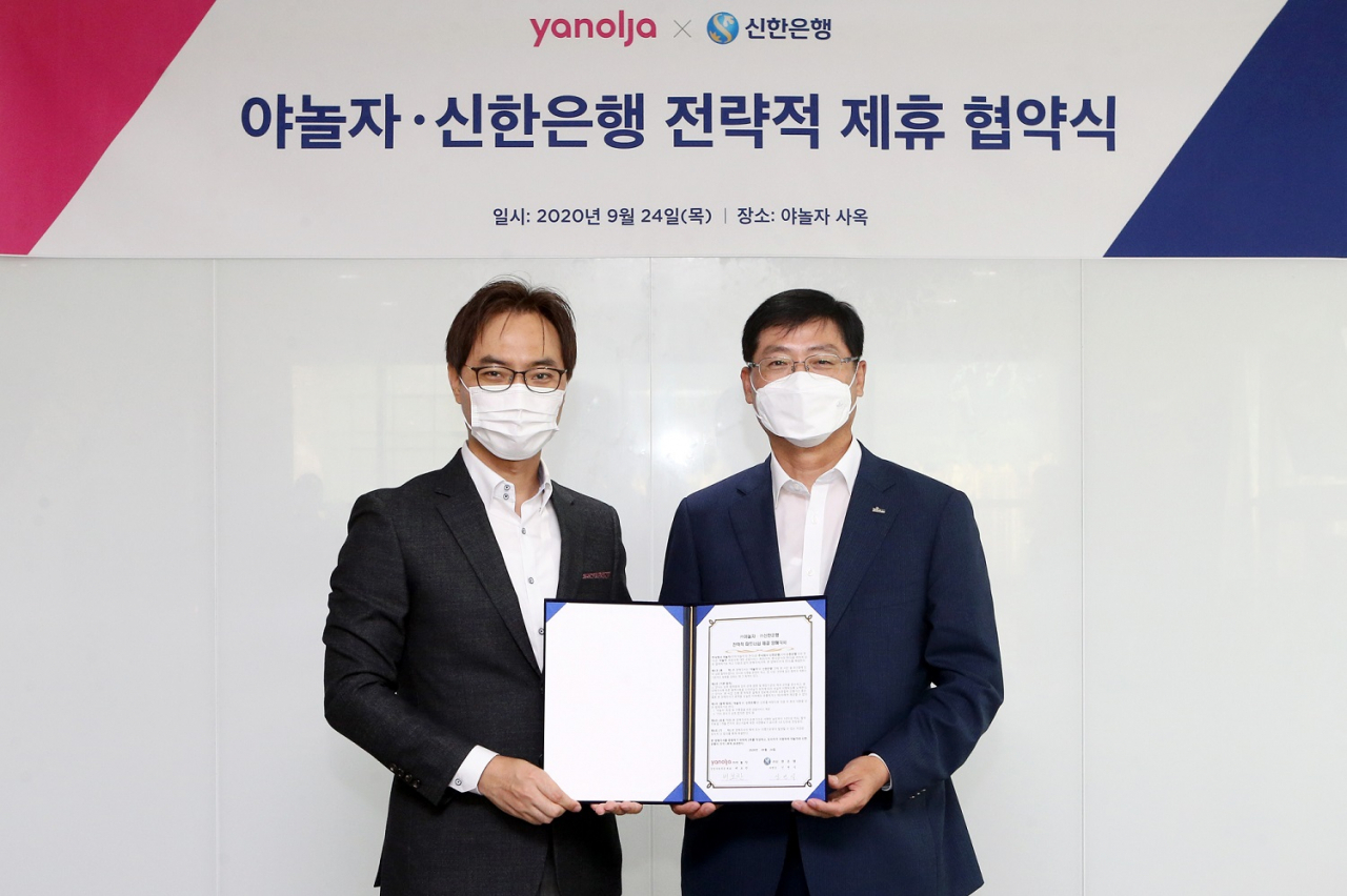 지난 24일 서울시 강남구 테헤란로에 위치한 야놀자 사옥에서 진행된 ‘신한은행·야놀자 전략적 제휴 협약식’에서 협약을 마친 후 신한은행 기업그룹 신연식 부행장(오른쪽)과 야놀자 배보찬 경영지원부문 대표가 기념촬영 하고 있다.