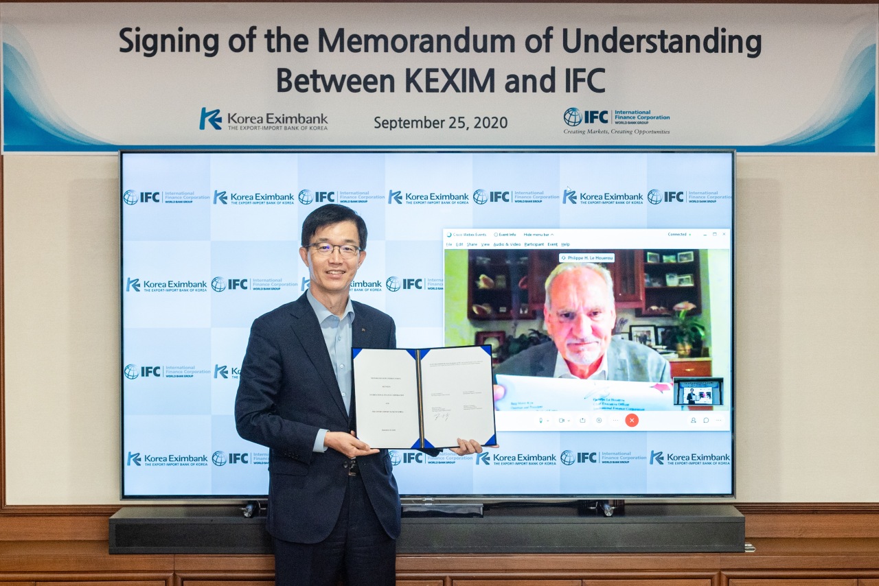 The Export-Import Bank of Korea Chairman Bang Moon-kyu (left) poses at a signing ceremony with IFC Chief Executive Philippe Le Houerou during a virtual meeting held Friday to sign a memorandum of understanding. (Eximbank)