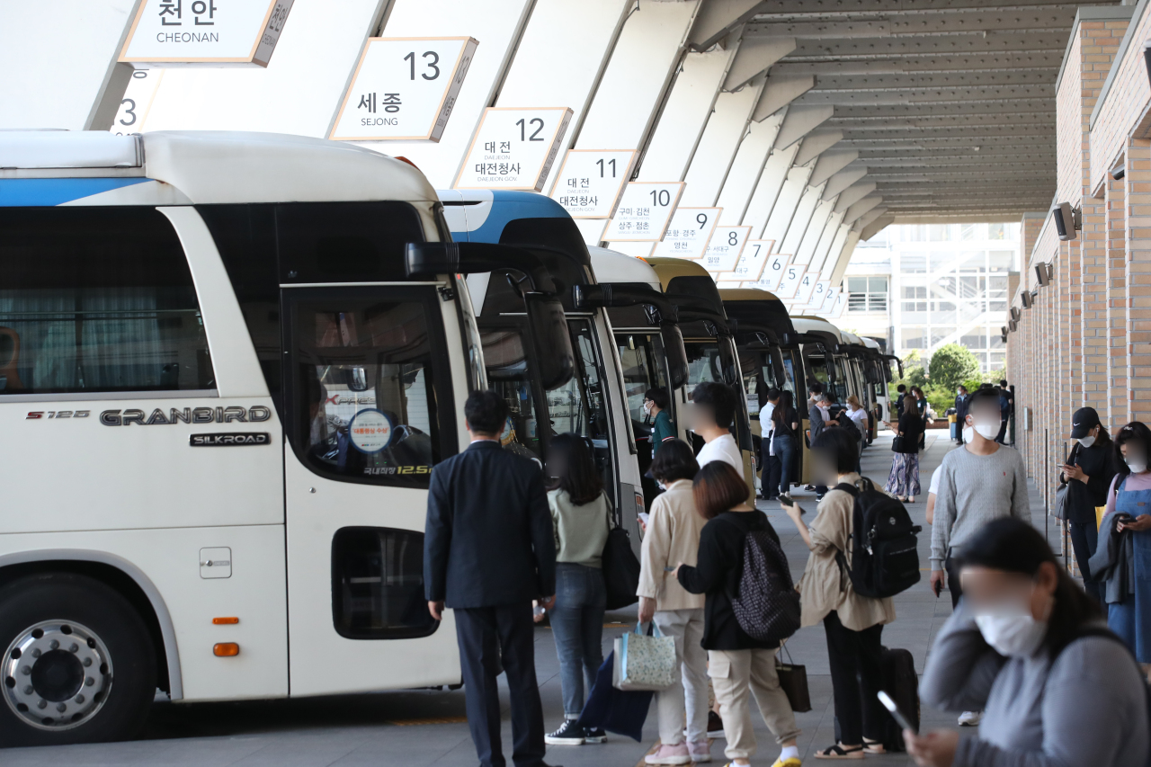 Passengers board buses Sunday at the Seoul Express Bus Terminal ahead of the Chuseok holiday period starting Wednesday. (Yonhap)