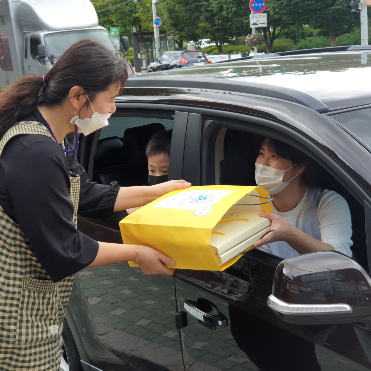 어린이집 영유아 학부모가 건강간식꾸러미를 전달 받고 있다. [도봉구 제공]