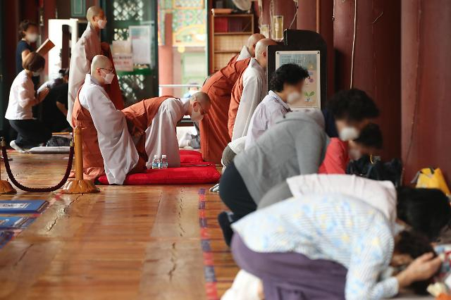 지난 17일 서울 종로구 조계사에서 수도권 사회적 거리두기 2단계 완화 이후 열린 초하루 법회에서 스님과 불교 신자들이 기도를 드리고 있다. 연합뉴스