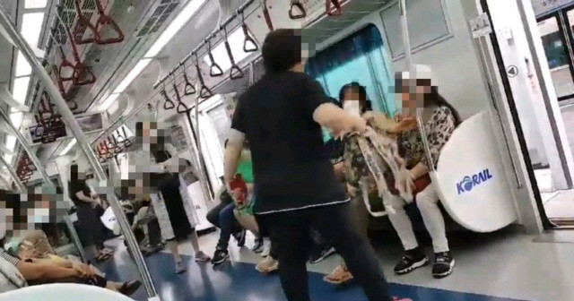 지난 6월 지하철 열차에서 한 여성이 마스크 미착용에 항의하는 시민에게 난동을 부리고 있다. [연합뉴스]
